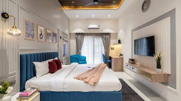 Un dormitorio moderno con una cama grande, un televisor y un ventilador de techo.