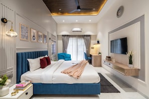 Un dormitorio moderno con una cama grande, un televisor y un ventilador de techo.