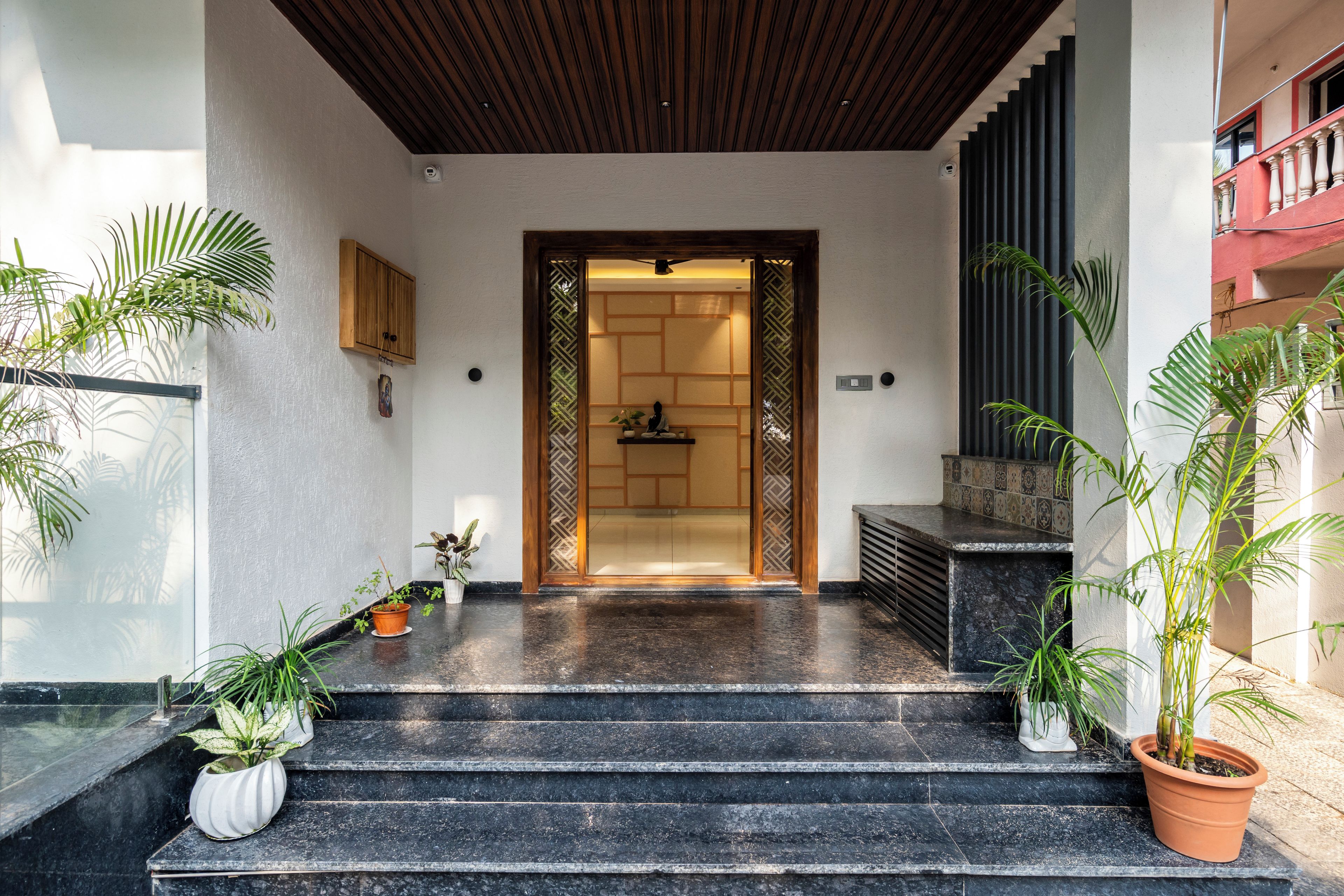 A staircase leading to a room with a wooden ceiling and a view of a balcony.