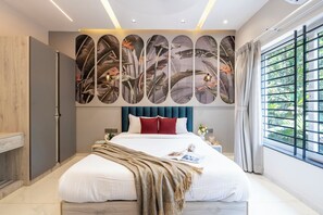 A modern bedroom with a large bed, a decorative wall, and a window with curtains. - Staymaster Aanshal-4BR Villa with Pool (Nerul)
