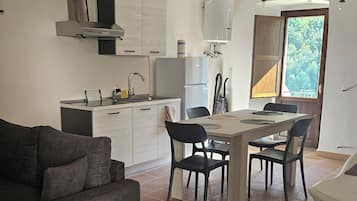 Una cucina moderna con zona pranzo, divano e vista sull'esterno.