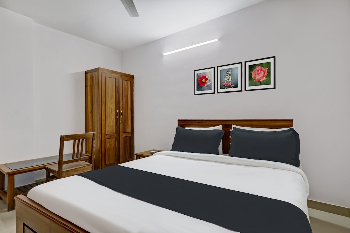 Un dormitorio con cama, armario de madera, silla y tres cuadros en la pared.