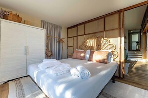 Un dormitorio con cama, armario y ventana grande.