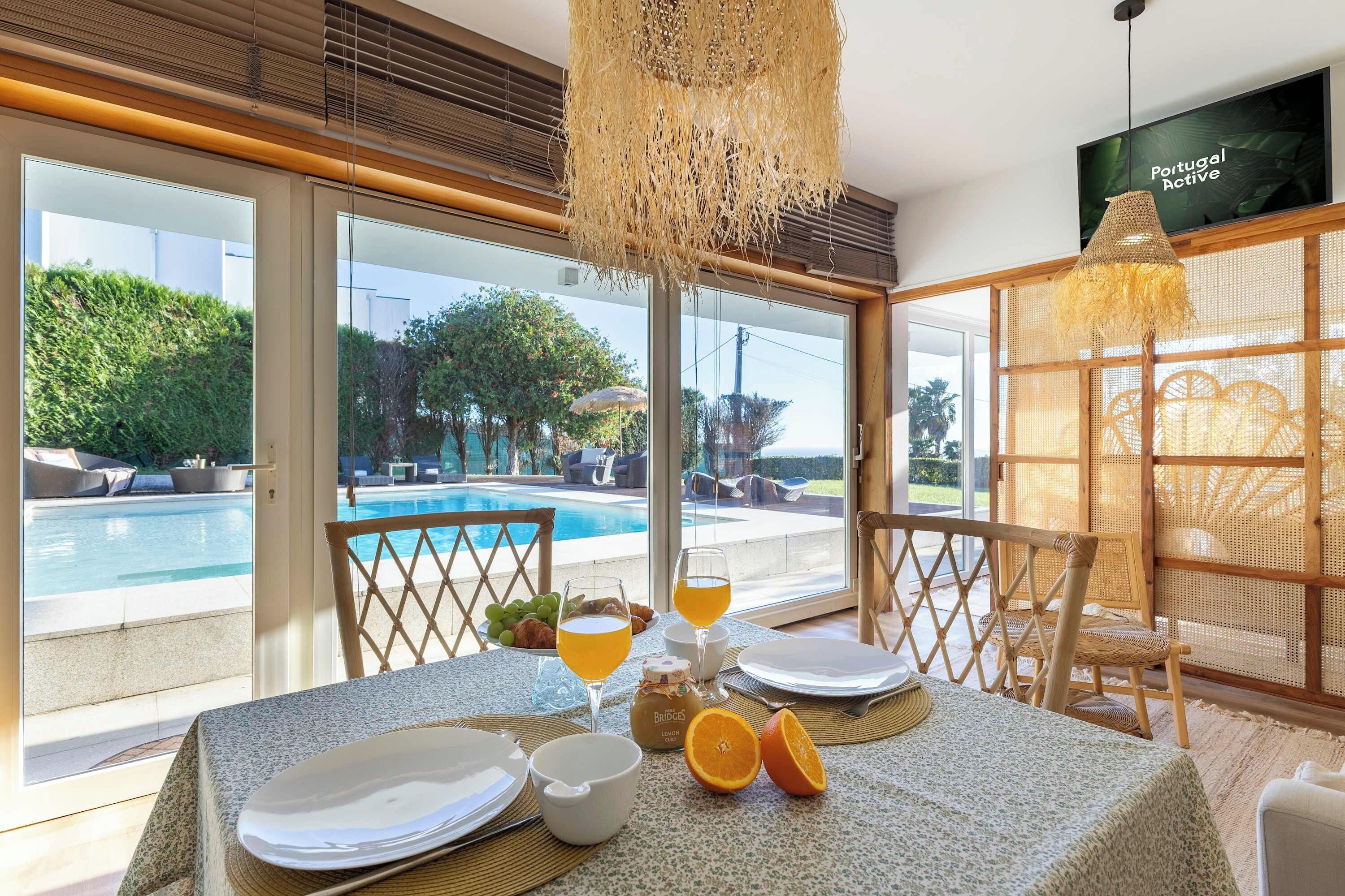 Comedor con vistas a una piscina, mobiliario exterior y una silla de mimbre.