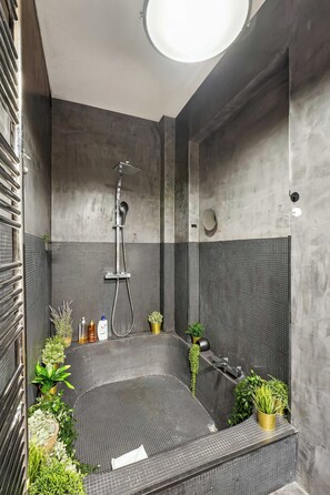 Une salle de bain moderne équipée d’une douche, d’une baignoire et de divers produits de toilette.