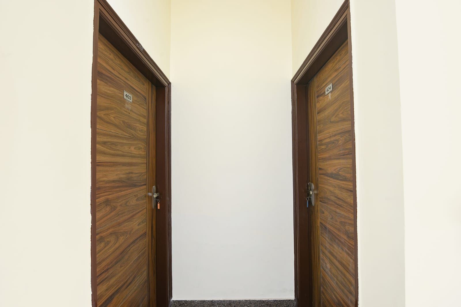 A hallway with two wooden doors, each marked with a number.