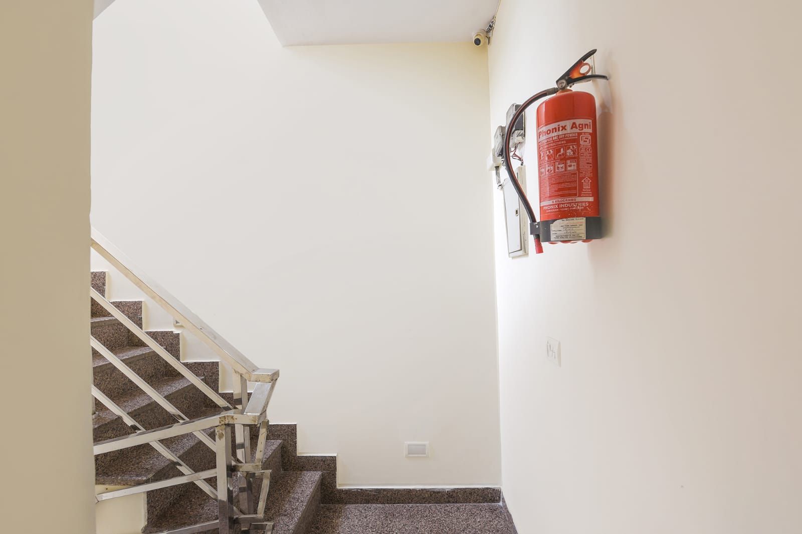A staircase with a fire extinguisher mounted on the wall.