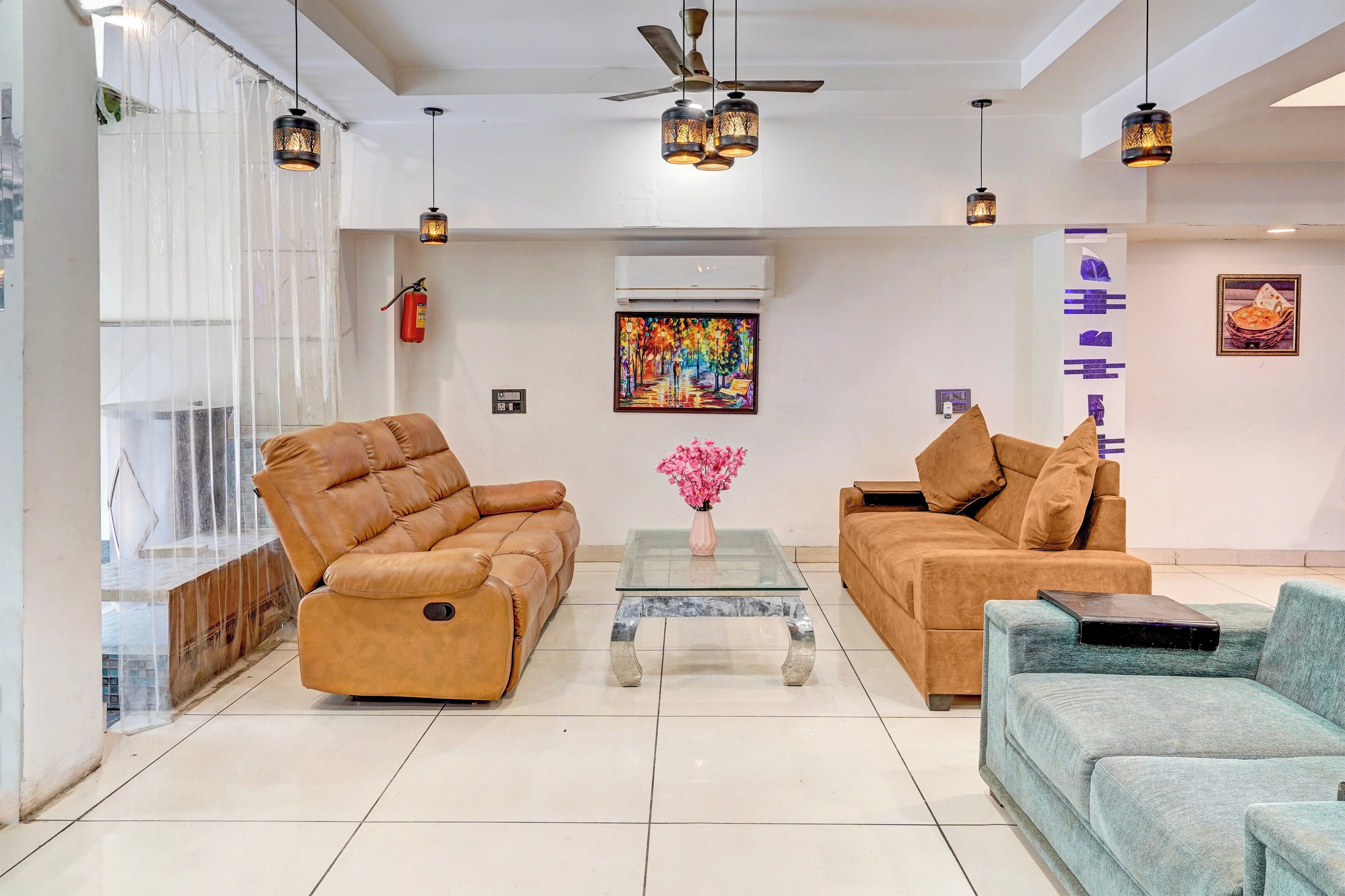 Una sala de estar moderna con dos sofás de cuero, una mesa de centro de vidrio y objetos decorativos.