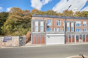 A two-story residential building with a brick facade, large windows, and a garage door. - Host & Stay | Fish Quay View (Tynemouth)