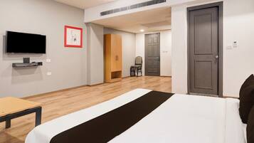 Una habitación de hotel con cama, televisión, armario y escritorio.