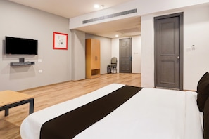 Una habitación de hotel con cama, televisión, armario y escritorio.