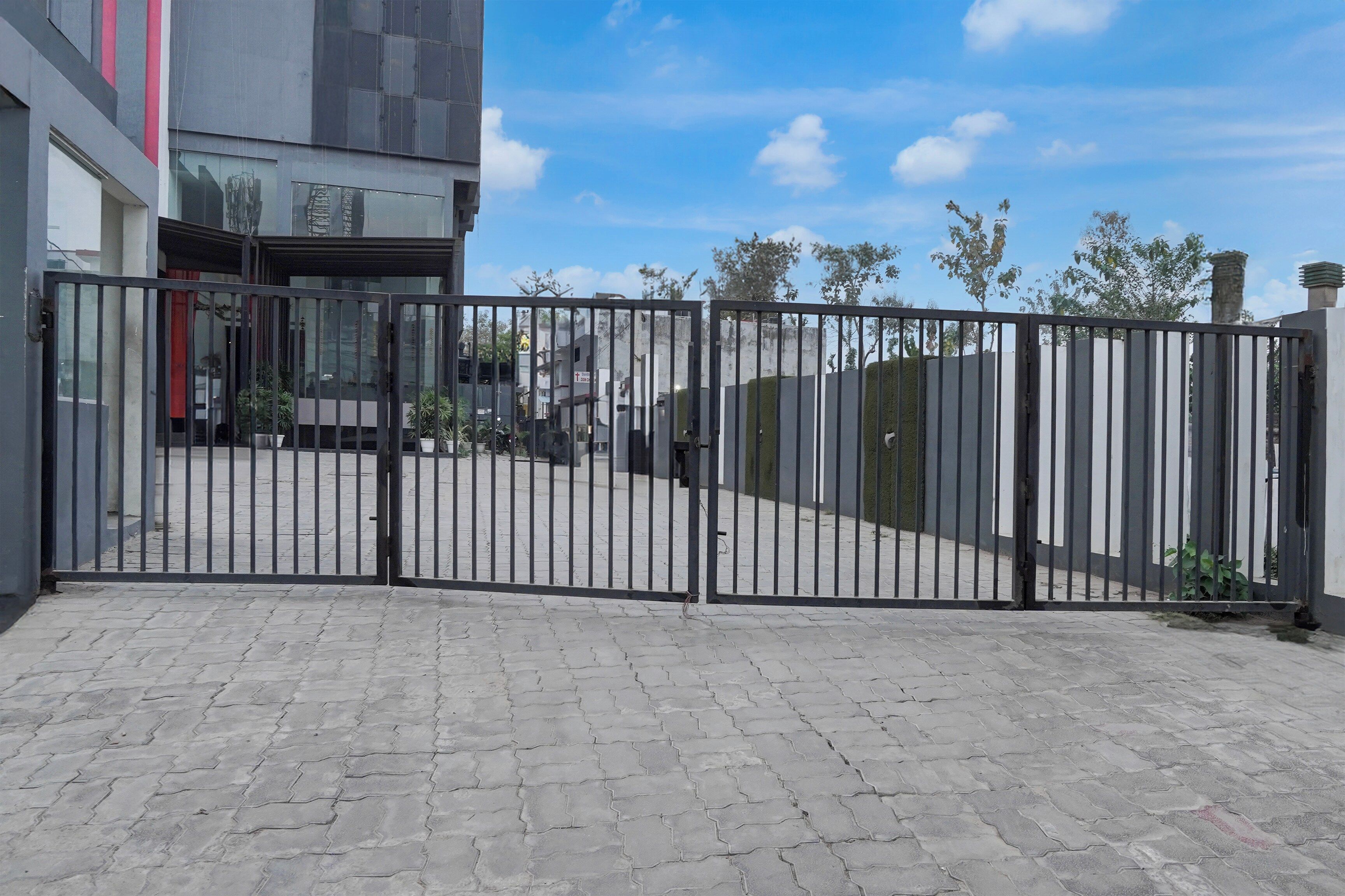Una entrada con acceso restringido y un camino pavimentado que conduce a un edificio.