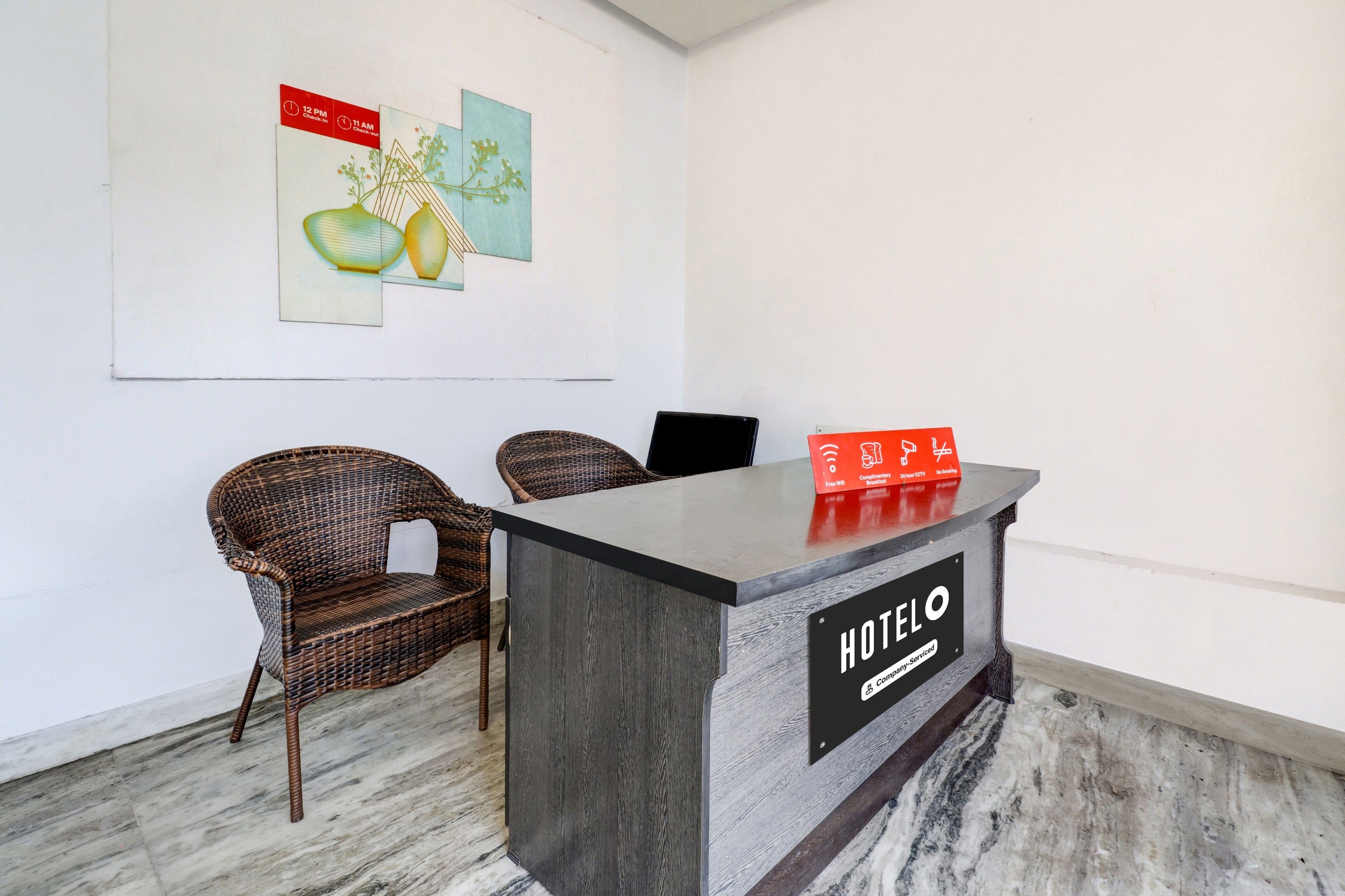 Taulell de recepció d'hotel amb un cartell que indica esmorzar gratuït i Wi-Fi gratuït.