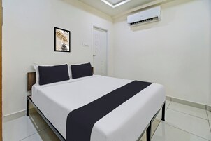 Una habitación de hotel con una cama, aire acondicionado de pared y una puerta.