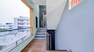 Un edificio residencial con balcón, escaleras y vista a edificios vecinos.