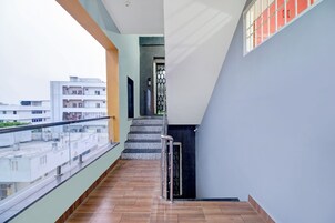 Un edificio residencial con balcón, escaleras y vista a edificios vecinos.