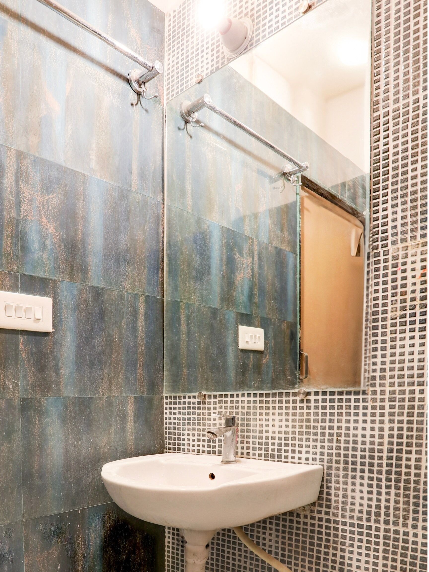 A bathroom with a white sink, a mirror, and a shower area.