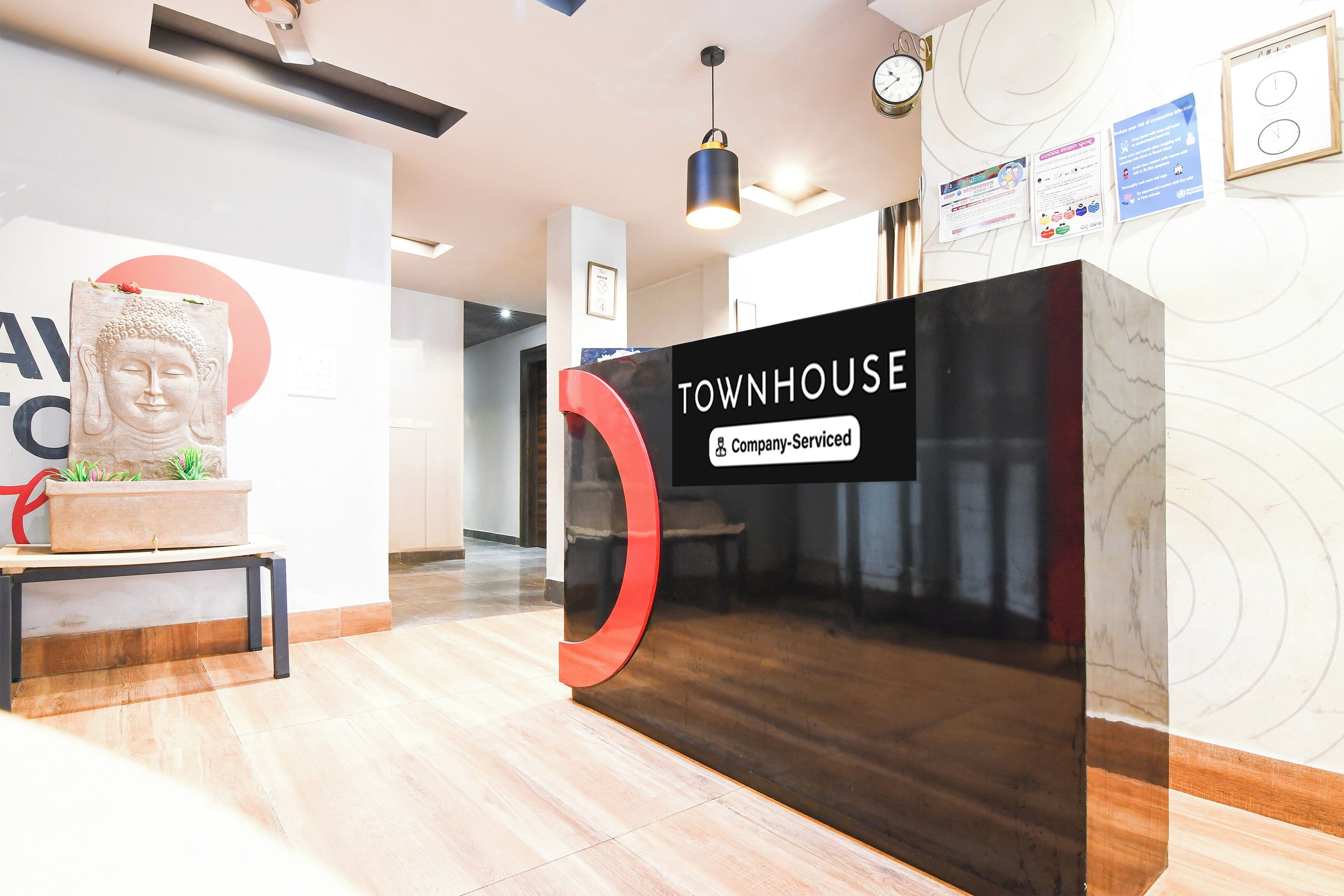 A reception desk with a sign that reads 'TOWNHOUSE & Company Serviced'.