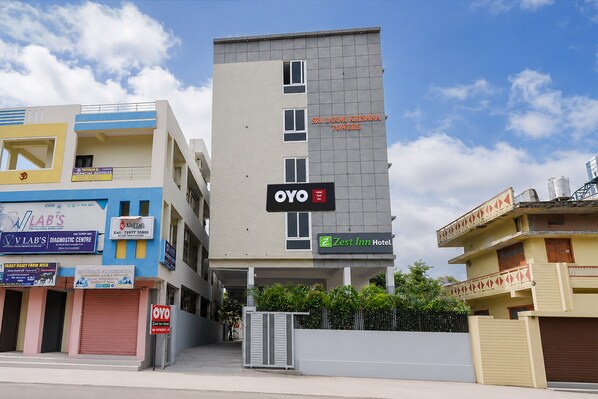 Un edificio de varios pisos con un letrero que indica OYO Zest Inn Hotel.
