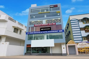 A multi-story building with signage for 'PRIDE Rooms,' 'SUBHAM BANQUET HALL,' and 'PRIDE INSTITUTE OF HOTEL MANAGEMENT.' - Hotel O R Eleven (Hyderabad)