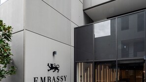 A building entrance with a sign reading 'EMBRASSY' and a lion logo. - Richmond Rhythm | City Living & Lifestyle (Richmond)
