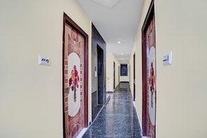 Un pasillo de hotel con suelo de mármol, puertas de madera y un cartel que indica la habitación número 405.