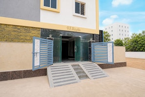 A building entrance with a double door and a ramp leading up to it.