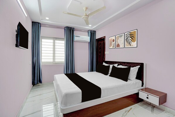 A bedroom with a bed, a nightstand, a ceiling fan, a window with curtains, and wall art.