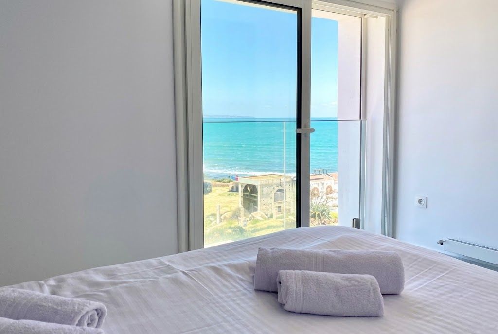 Une chambre avec une grande fenêtre donnant sur la mer.