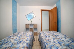 A bedroom with two beds, a mirror, a wooden cabinet, and a door. - Apartment 'Kambusa Homes - Al Porto - Destra' with Sea View, Wi-Fi and Air Conditioning (Torre Vado)