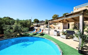 Piscina com escorregadores, área de estar externa e um terraço coberto.