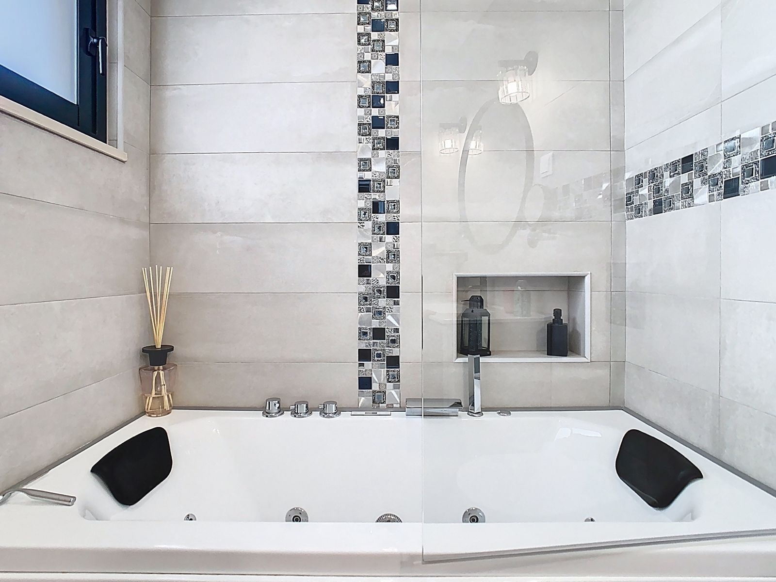 A modern bathroom with a large bathtub, a shower area, and a small shelf with toiletries.