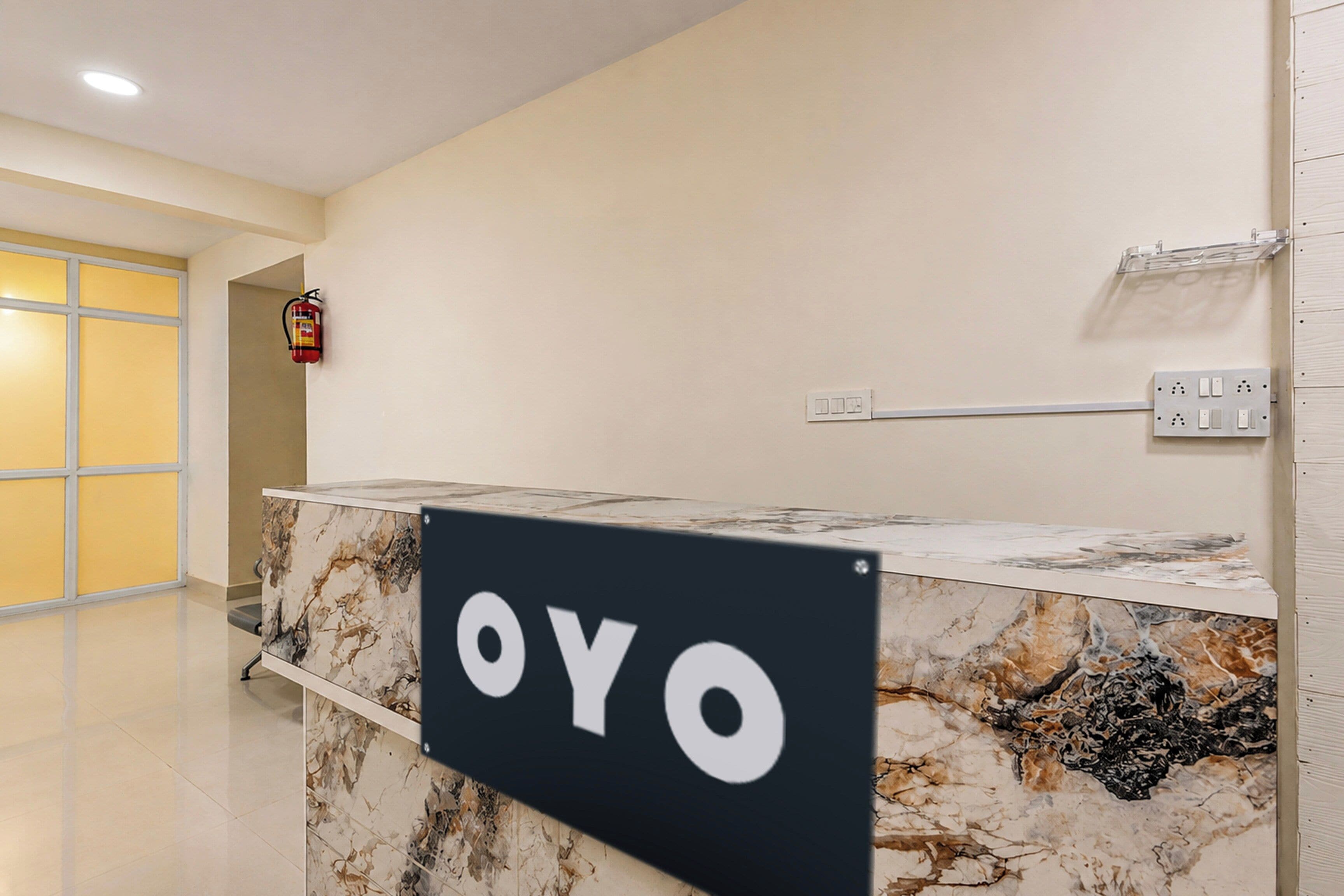 A reception desk with a marble top and a sign that reads 'OYO'.