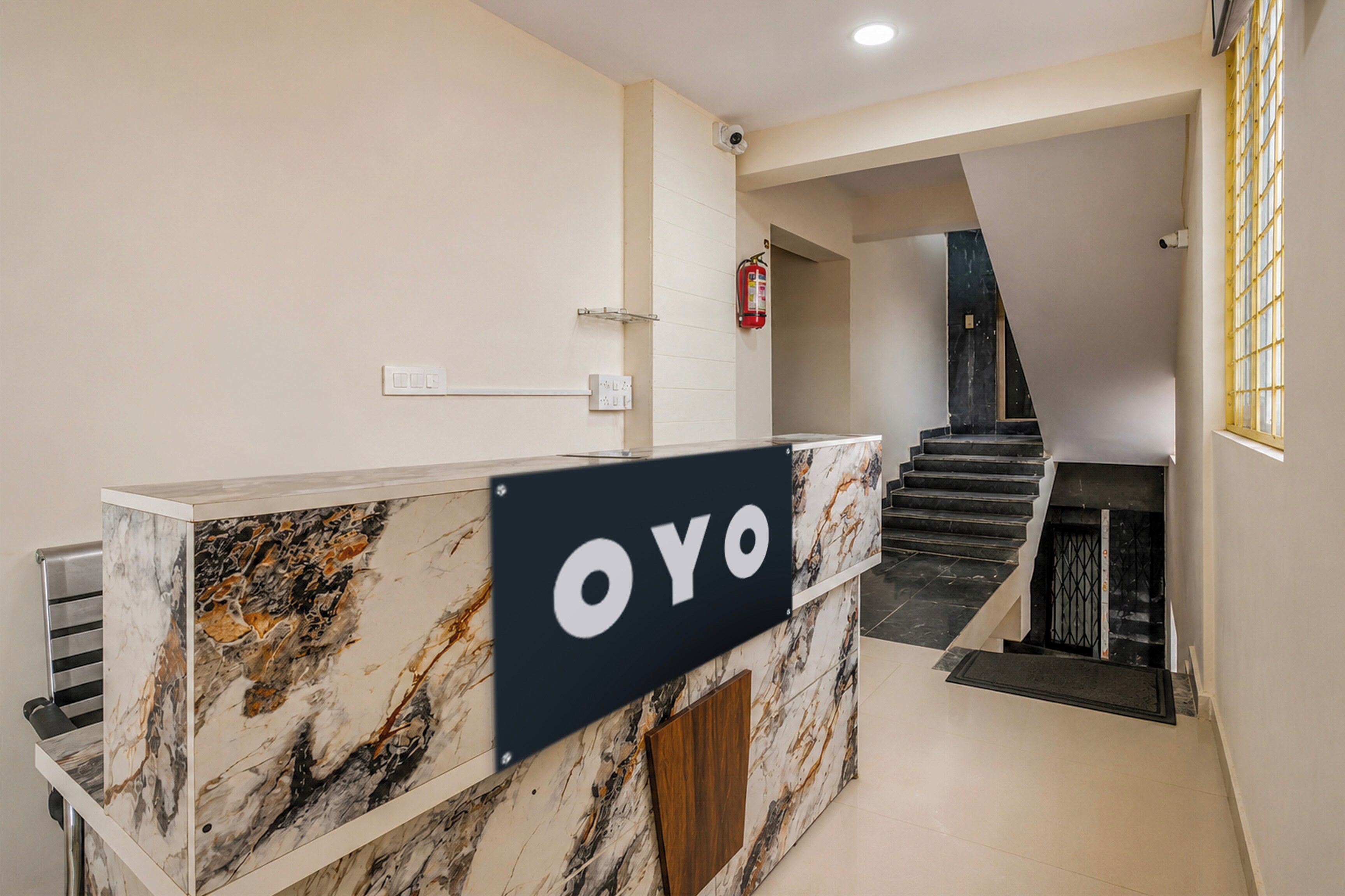 En receptionsdisk med marmordesign og et skilt med teksten 'OYO'.