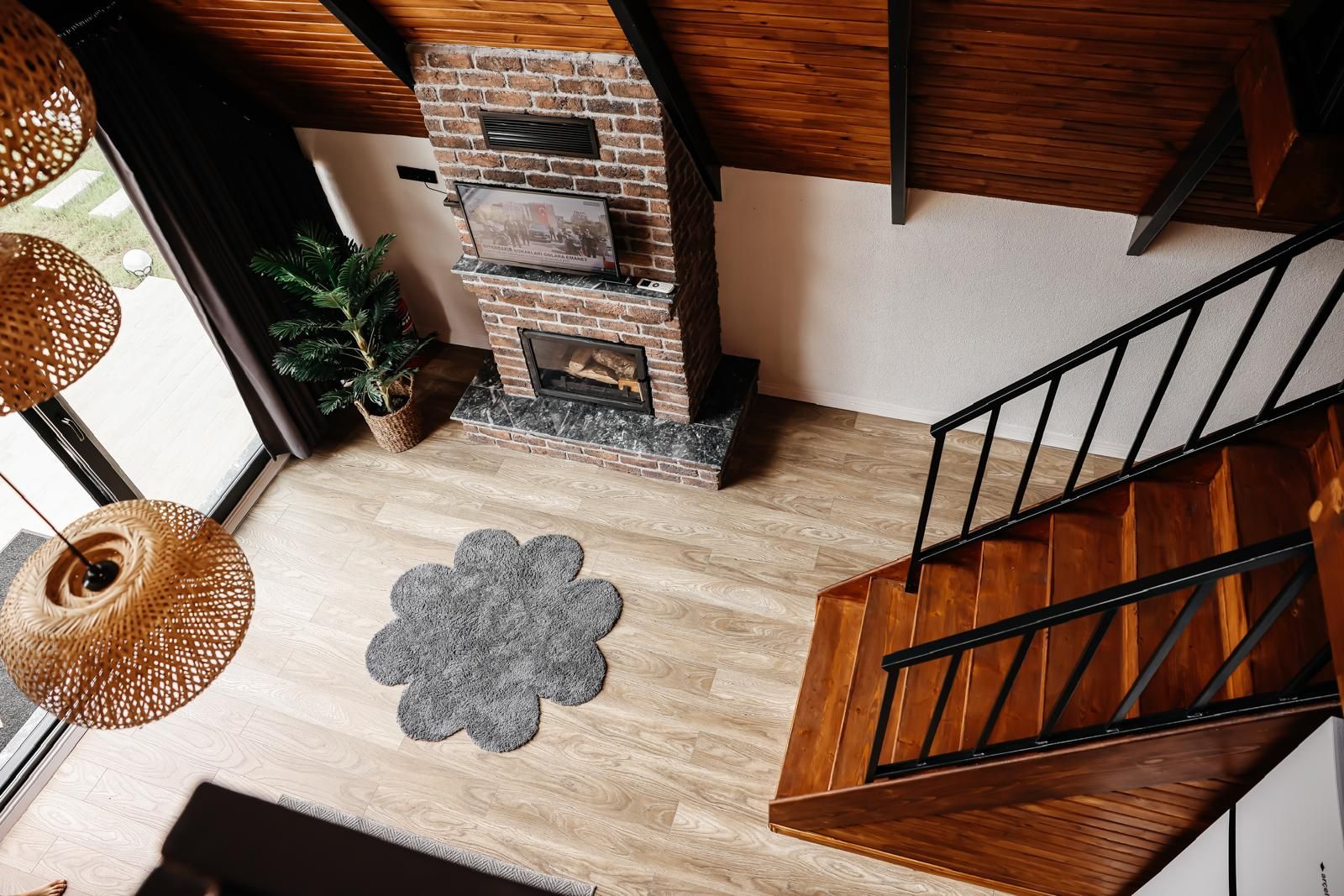 Ein modernes Interieur mit Kamin, Holztreppe und einem dekorativen Teppich.