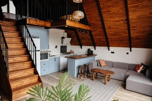 Un loft moderno con cocina, comedor y escalera.