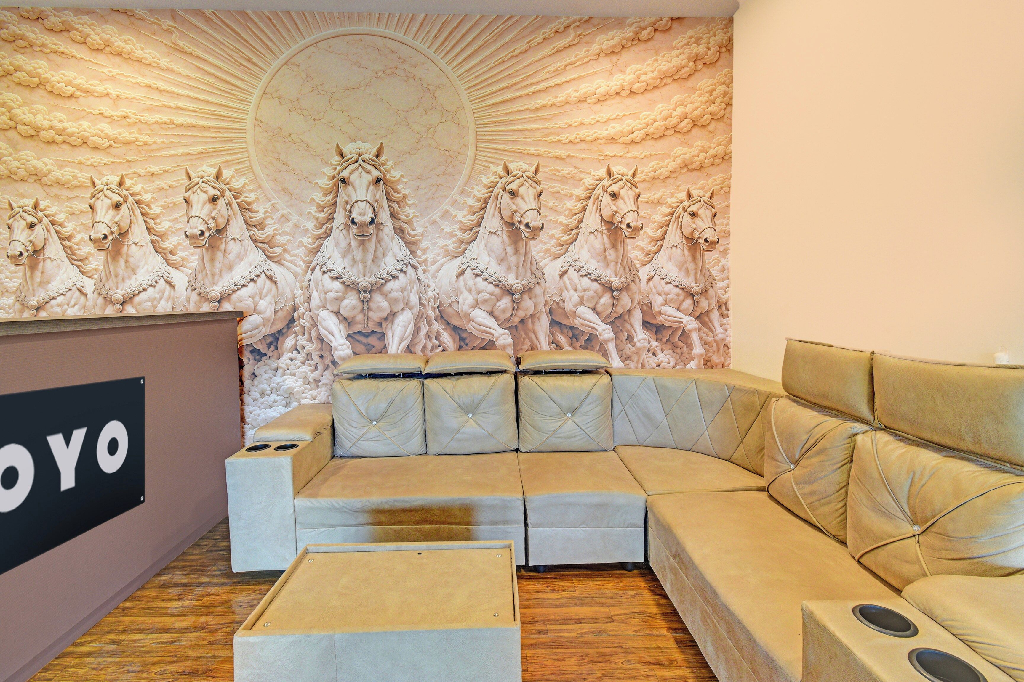 Una habitación con un amplio mural en la pared de caballos, un sofá y una recepción.