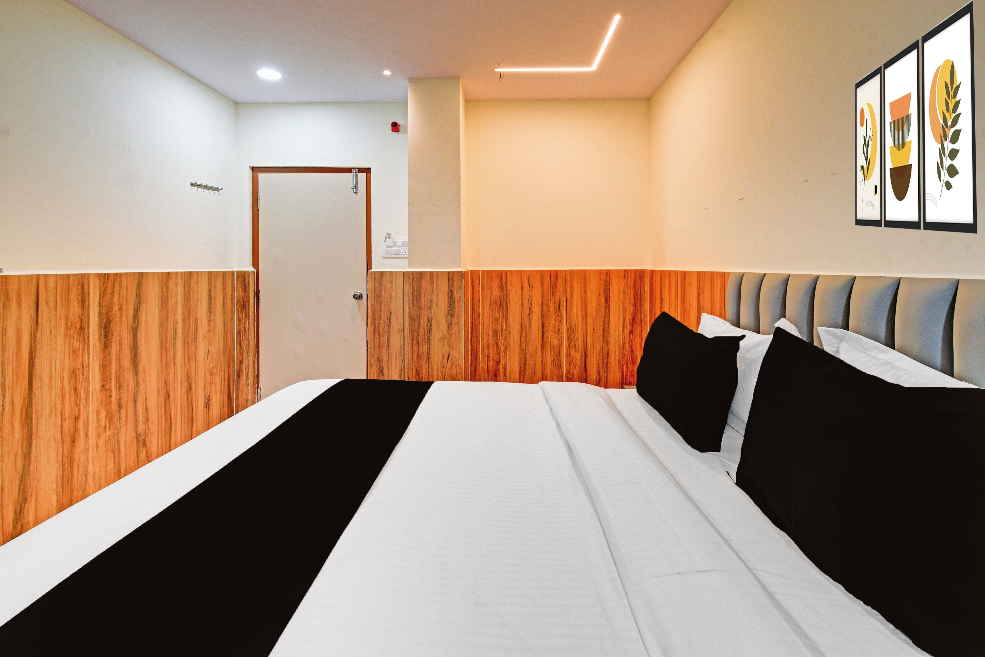 Habitación de hotel con cama, paneles de madera, una puerta y decoración en la pared.