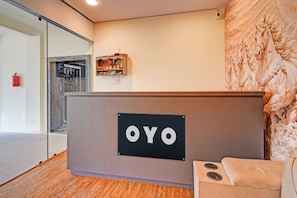 A reception desk with a sign that reads 'OYO' and a wall with a carved horse sculpture. - HOTEL O VEDHANSHI HOTEL BIBINAGAR (Hyderabad)