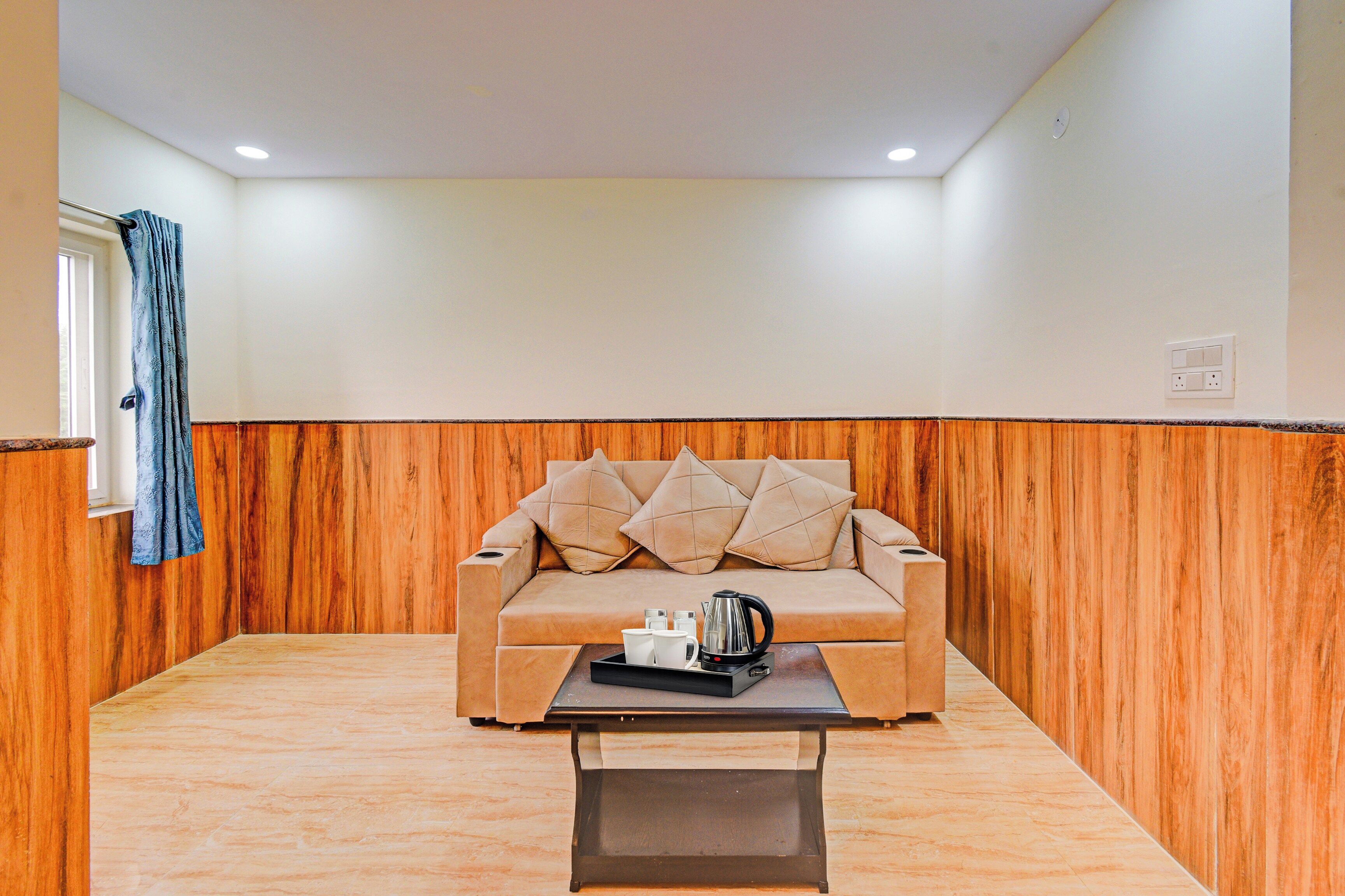 Una habitación con un sofá color crema, una mesita de centro y una pared de madera decorativa.