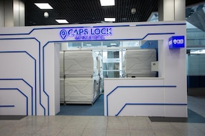 A capsule hotel entrance with a modern design, featuring a prominent signage for 'Caps Lock Capsule Hotel.' - CAPSLOCK (Almaty)