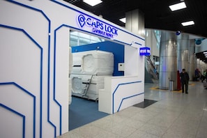 A capsule hotel with a modern design, featuring a prominent entrance and a visible elevator. - CAPSLOCK (Almaty)