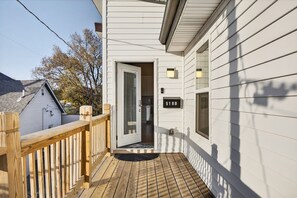 A wooden deck leading to a white house with a door and a mailbox. - 6BR/4BA Duplex | 10 Minutes to Downtown, Lucas Oil & Gainbridge (Indianapolis)