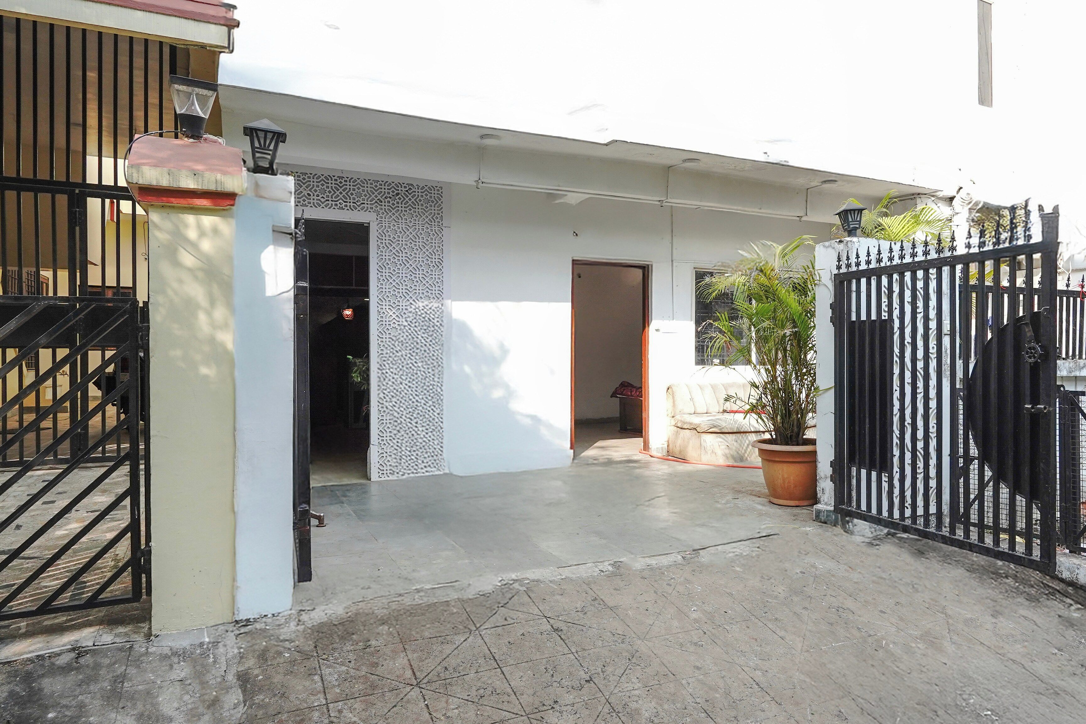 A gated entrance to a property with a concrete pathway leading to a door.