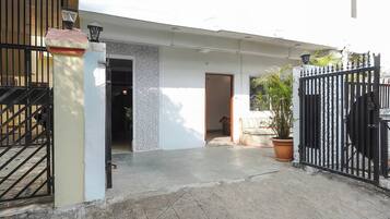 A gated entrance to a property with a concrete pathway leading to a door.