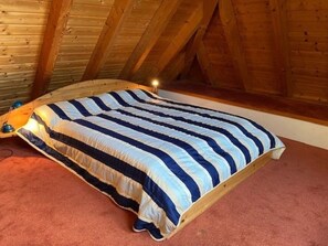 A single bed in a room with wooden beams on the ceiling. - Strandstrasse 28, Half of the House on the Left (Nieblum)