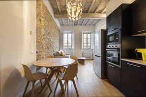 A modern kitchen with dark cabinetry, a built-in oven, and a microwave. - Colonna Suite by MMega Homes and Villas (Florence)