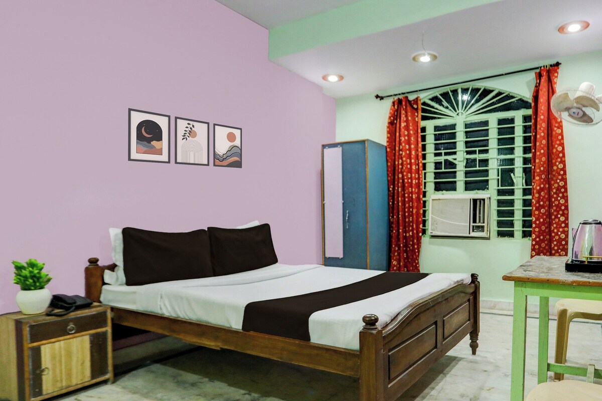 Un dormitorio con cama, escritorio, armario y ventana con cortinas.