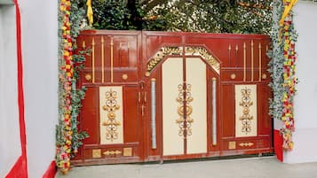 A red and cream-colored gate with ornate gold detailing and floral decorations.