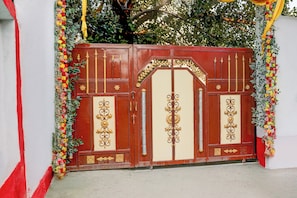 A red and cream-colored gate with ornate gold detailing and floral decorations. - Super Hotel O Anjanpeer Post Office (Hajipur)